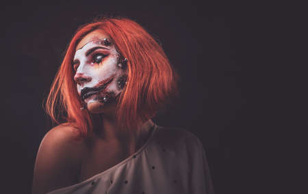 Portrait of ginger girl in role of creepy doll on Halloween.の写真素材