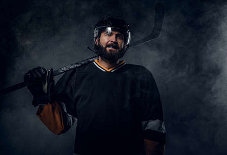 Happy toothless hockey player is posing for photographer with hockey stick.の写真素材