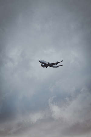 Aeroplane in the cloudy sky is flying from aeroport after summer rain.の写真素材