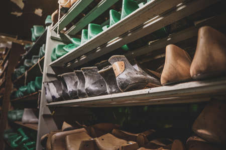 Dark storage with shelves and many forms for creating different shoes and boots.の写真素材