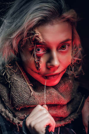 Blonde girl with scary lens is playing a role of creepy scarecrow.の写真素材