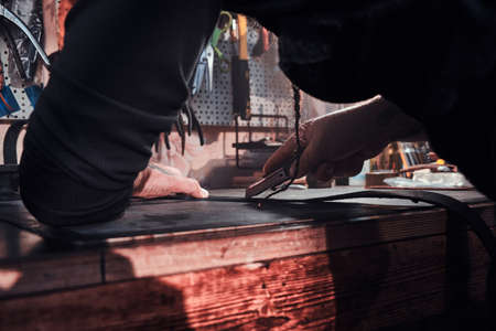 In the busy workshop talented master is making his masterpeace from leather.