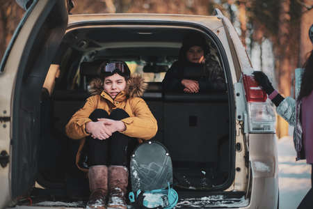 Two brothers and their mum are posing for photographer while sitting in the car.の写真素材