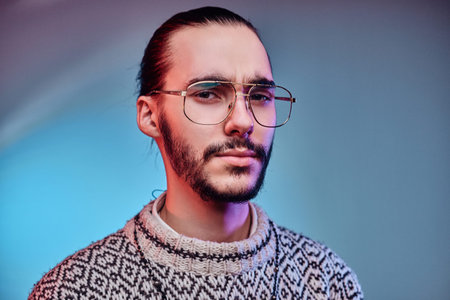Sceptical tired man in glasses is posing for photographer at studio.の写真素材