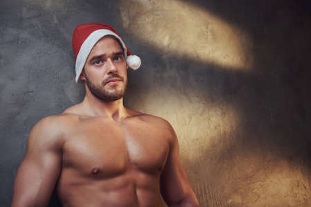 Hot sexy male is demonstrating his beautiful fit body wearing Santa hat.の写真素材