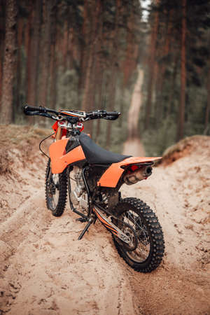 Orange motocross bike on sand in forestの写真素材