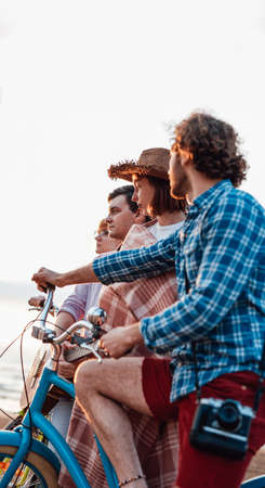Teenagers are spending their free time on the beach, cycling, having nice timeの写真素材