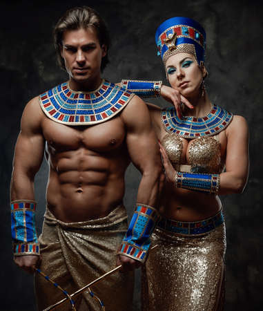 Attractive woman in traditional egyptian costume with her arm laid on male shoulder. Man holds...