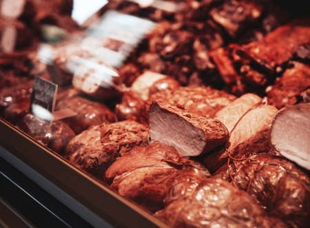 Close up of smoked brown meat. Fresh and deli product. Meat shop business.の写真素材