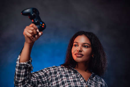 Gaming entertainment and hobby that youth likes and afro girl which holds in her hands joystick.の写真素材