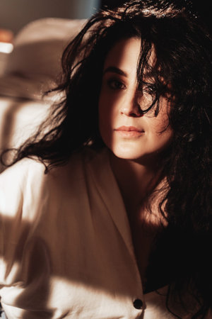 Mysterious and vintage styled photo of pretty woman which lying and relaxing on bed in hotel room.