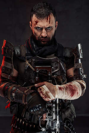 Portrait of staring at camera with serious face stalker with damaged and bandaged arm holds his...