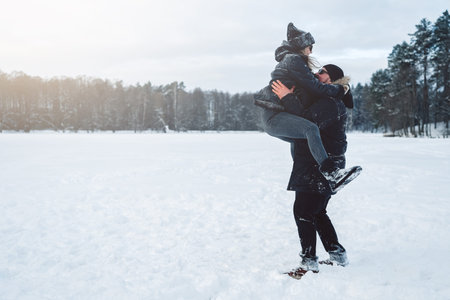 Happiness and leisure activity of couple in winter forest. Joyful wife and husband enjoy together on...