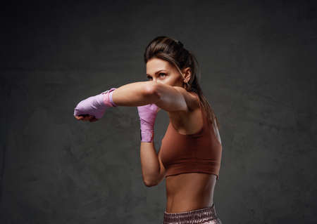 Sideview of a female fighter staying in defensive stance in studioの写真素材