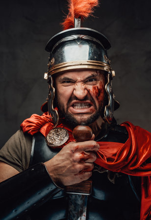 Mad armoured military roman screaming in dark backgroundの写真素材