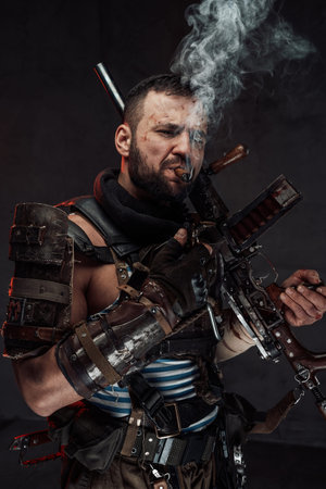 Self confident brutal stalker smokes cigar holding shotgunの写真素材