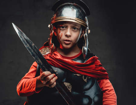Handsome roman little soldier with bloody arm and swordの写真素材