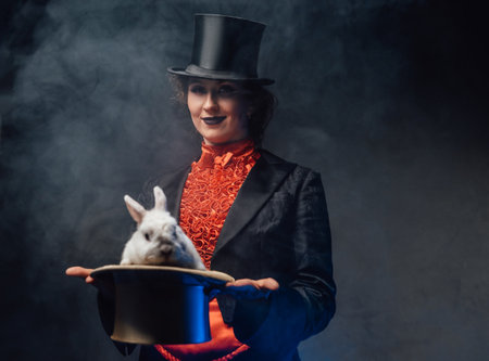 Attractive woman holding a top hat there is a white rabbit in smokeの写真素材