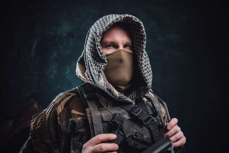 Modern army agent in camouflage clothing with a hood and rifleの写真素材