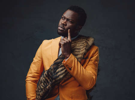 Fashionable black guy with fur wearing yellow coatの写真素材