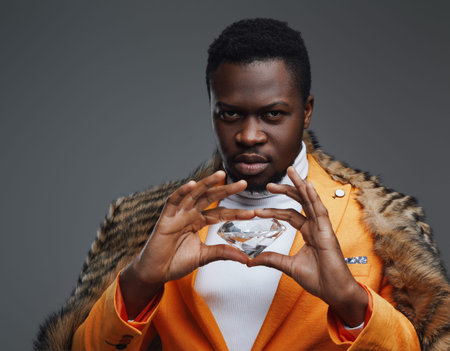 African businessman holding diamond in gray backgroundの写真素材