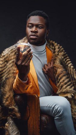 Stylish black man in yellow coat holding diamond