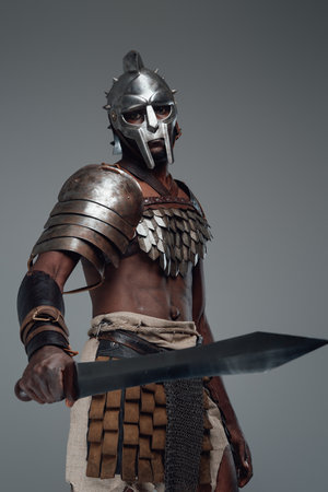 Combative black gladiator with sword in fight poseの写真素材