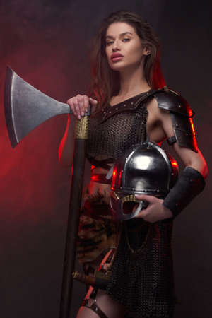 Wild northern valkyrie with axe and helmet in smokeの写真素材