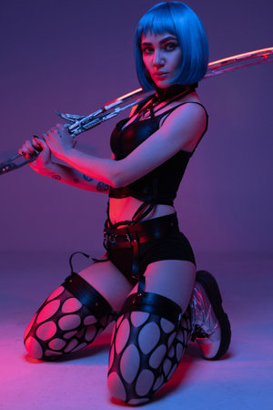 Seductive cyberpunk woman wielding glowing long swordの写真素材