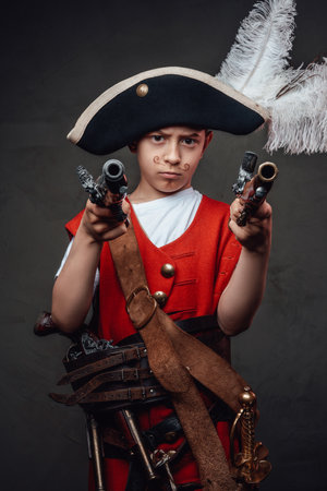 Preteen boy wearing carnival costume aiming gunsの写真素材