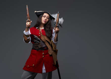 Brunette corsair with guns dressed in pirate outfitの写真素材