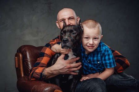 Isolated in dark background son father and dogの写真素材