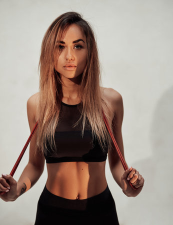 Sportswoman with resistance bands against white backgroundの写真素材