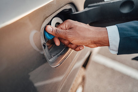 Shot of businessman opening fuel tank of his car
