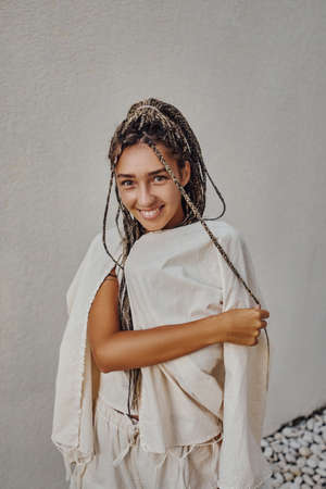 Smiling woman in trendy clothing posing against wallの写真素材