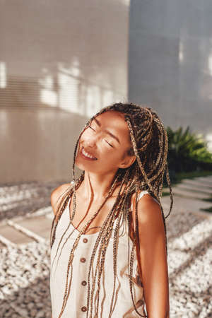 Happy woman in white summer clothing with dreadlocksの写真素材