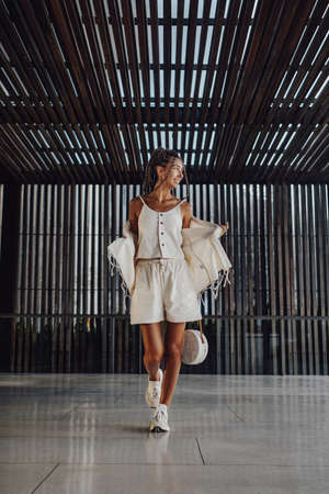 Happy woman in summer clothing posing inside room