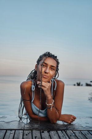 Happy woman wearing swimsuit swimming in poolの写真素材