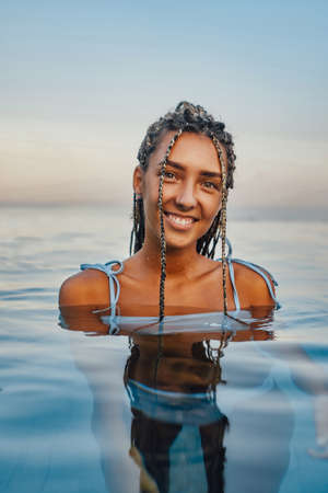 Woman with tanned skin swimming in pool of hotelの写真素材