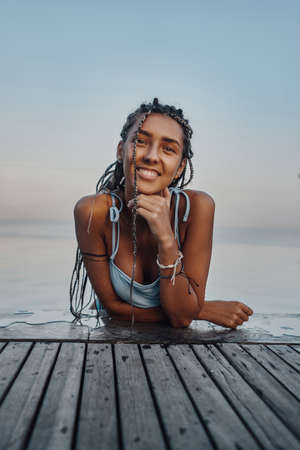 Happy woman wearing swimsuit swimming in poolの写真素材