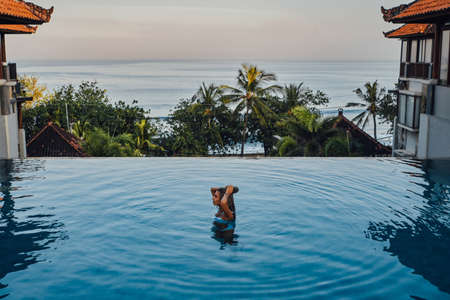 Woman on trip in bali enjoying swimming poolの写真素材