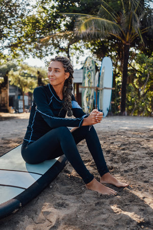 Sitting on board woman on beach around cafe