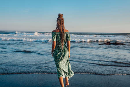 Backview of woman in dress against seascape in baliの写真素材