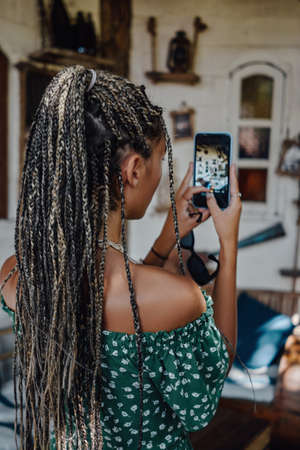 Backview shot of woman taking pictures on her phone