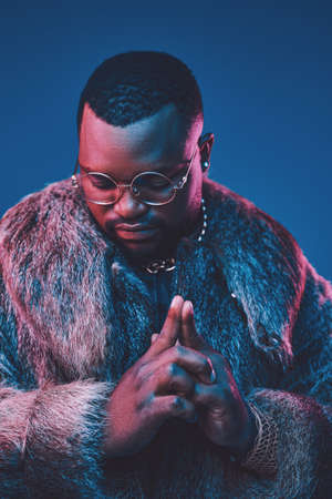 African man dressed in luxurious clothes against dark background