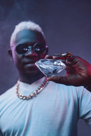 Rich african man with white hairs holding diamondの写真素材