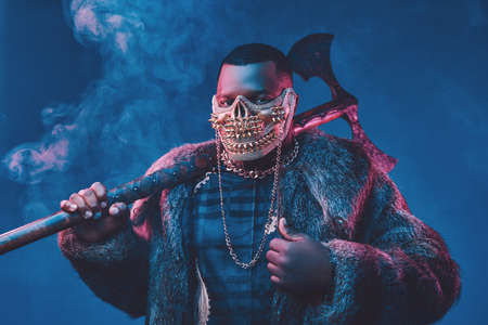 Evil african man with golden mask and huge axe