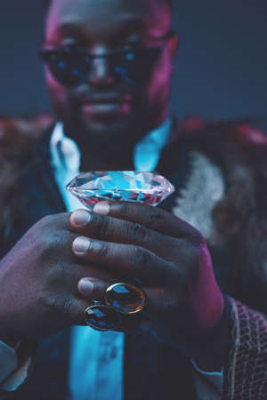 Elegant black man with fur coat holding brilliant