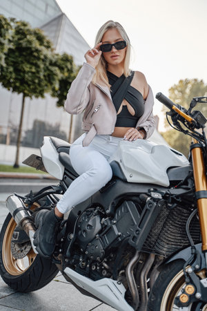 Female motorcycle driver posing outdoors in city in daytimeの写真素材