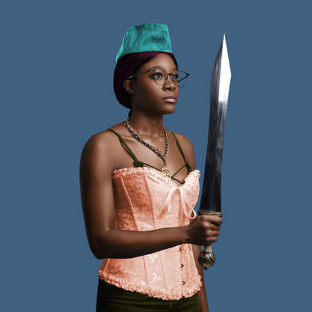 Woman of african ethnic holding sword against colorful backgroundの写真素材